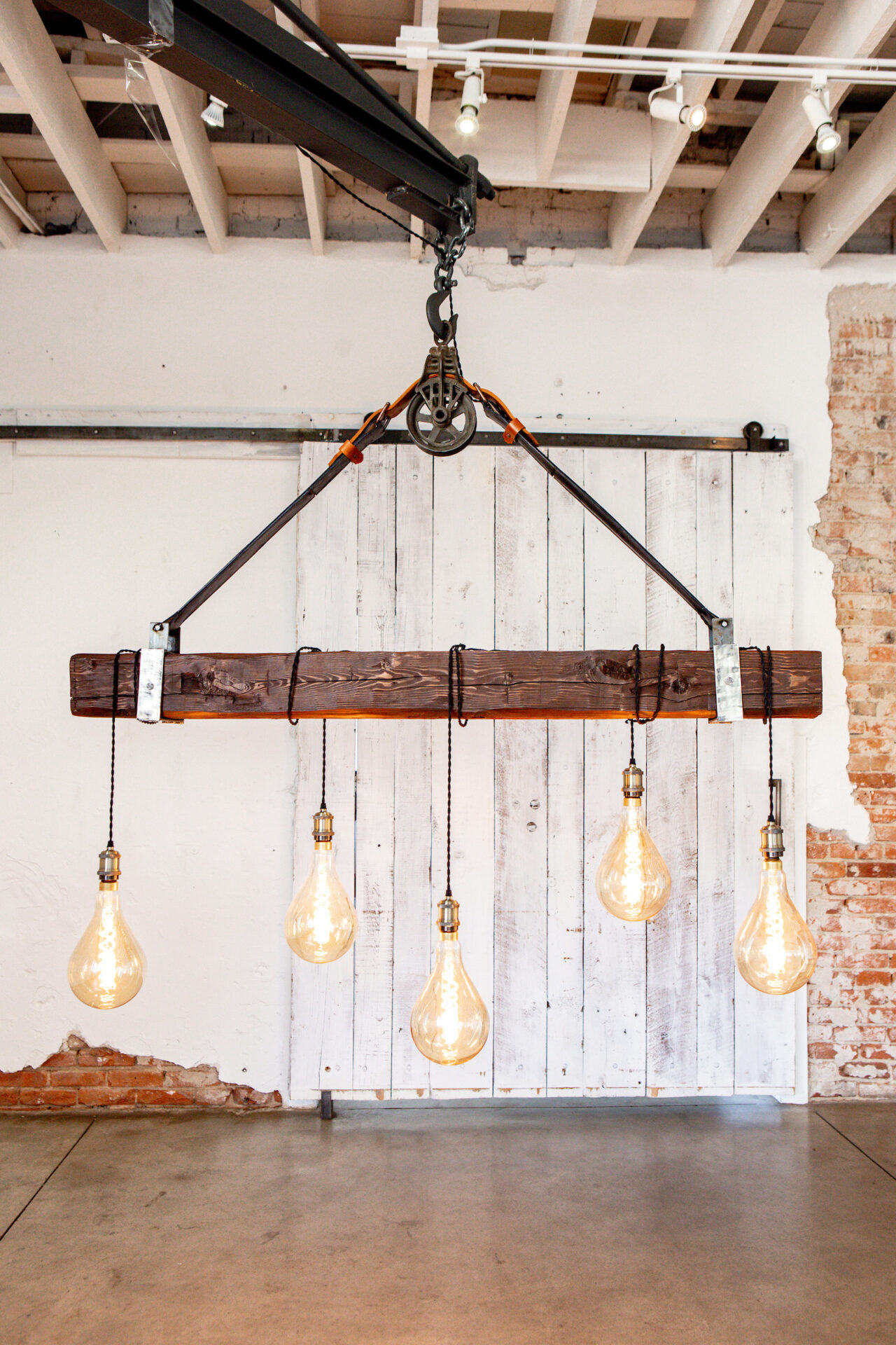 Champagne Leather & Wood Five light bulbs hanging from a wooden beam.