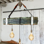 Champagne Leather & Wood Three light bulbs hanging from a wooden beam.